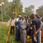 Groupe de participants rassemblés autour d'une station GNSS lors des travaux pratiques