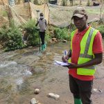 Deux techniciens relevant une section de cours d'eau, l'un à la canne GNSS, l'autre au carnet